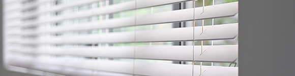 white venetian blinds installed on a window 